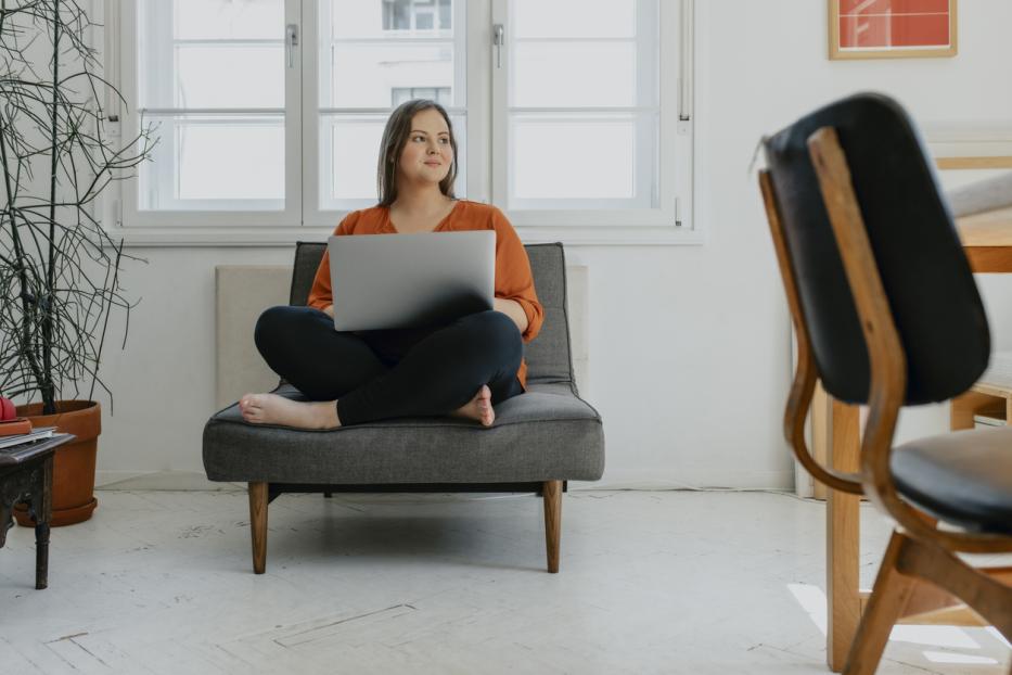 Women sitting on coach with her computer